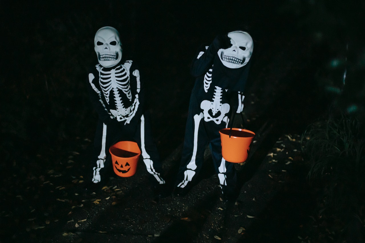 Kids trick-or-treat in skeleton costumes