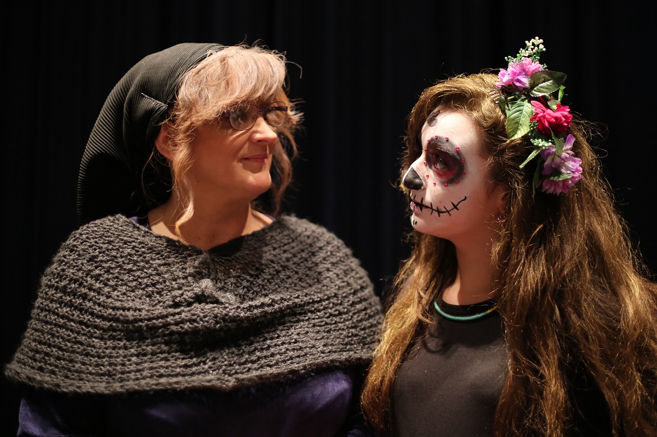 Two ladies in Halloween costumes dress as witch and skeleton